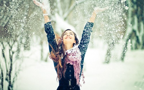 Девушка рассыпает снег над головой